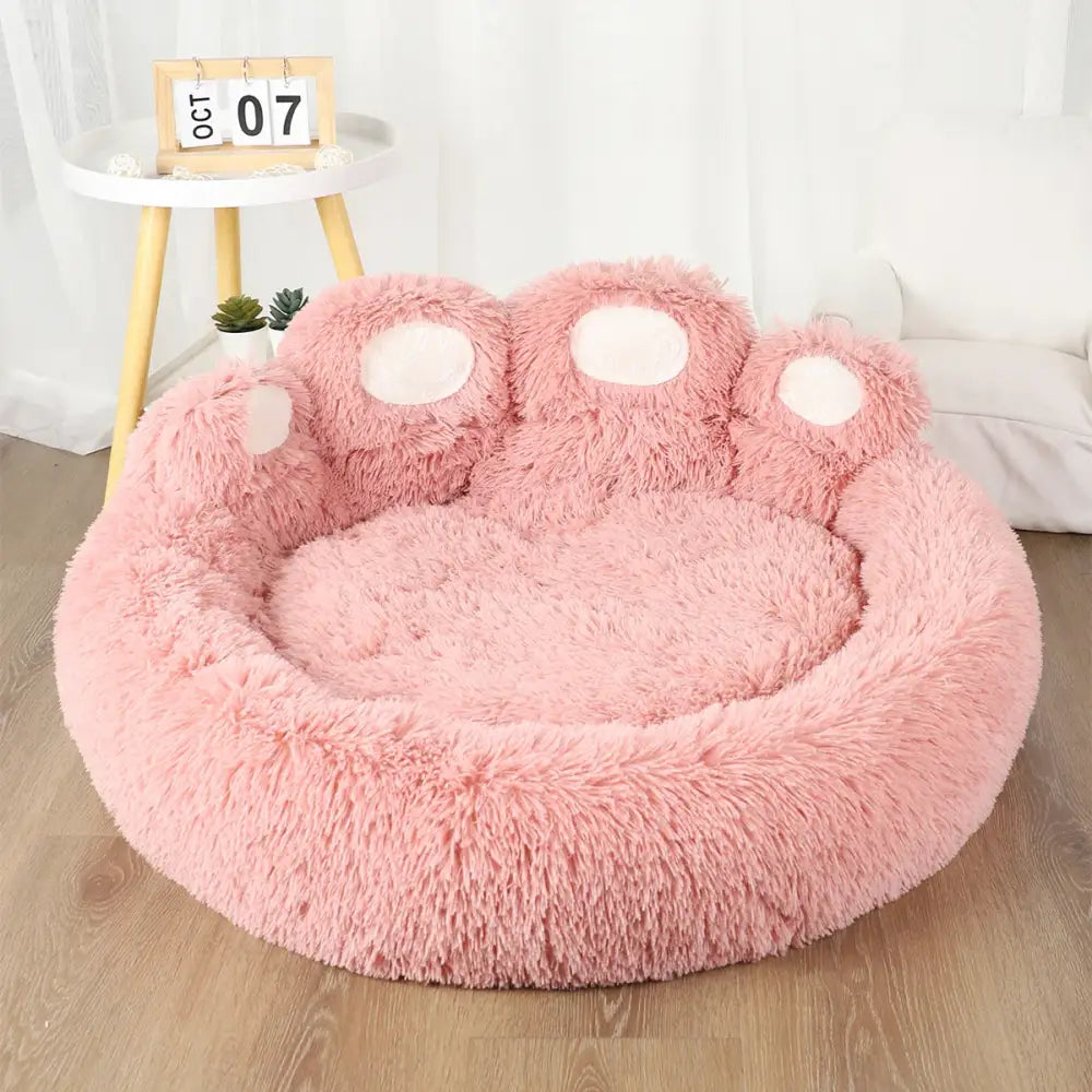Cozy pink plush sofa bed for dogs with paw design, ideal for small pets.